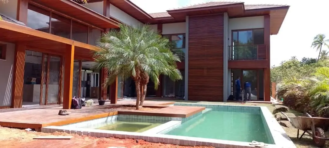 Residência em construção com esquadrias amplas e área de piscina
